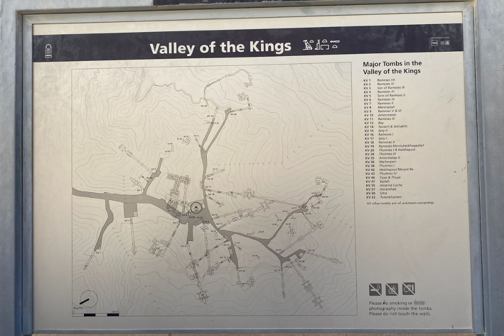 A detailed map of Luxor Valley of the Kings, mounted on a sign, showing the layout of major tombs and pathways. The map helps visitors navigate the valley of the kings and highlights key tombs including those of Tutankhamun and Ramesses. This guide is essential for a valley of the kings tour.