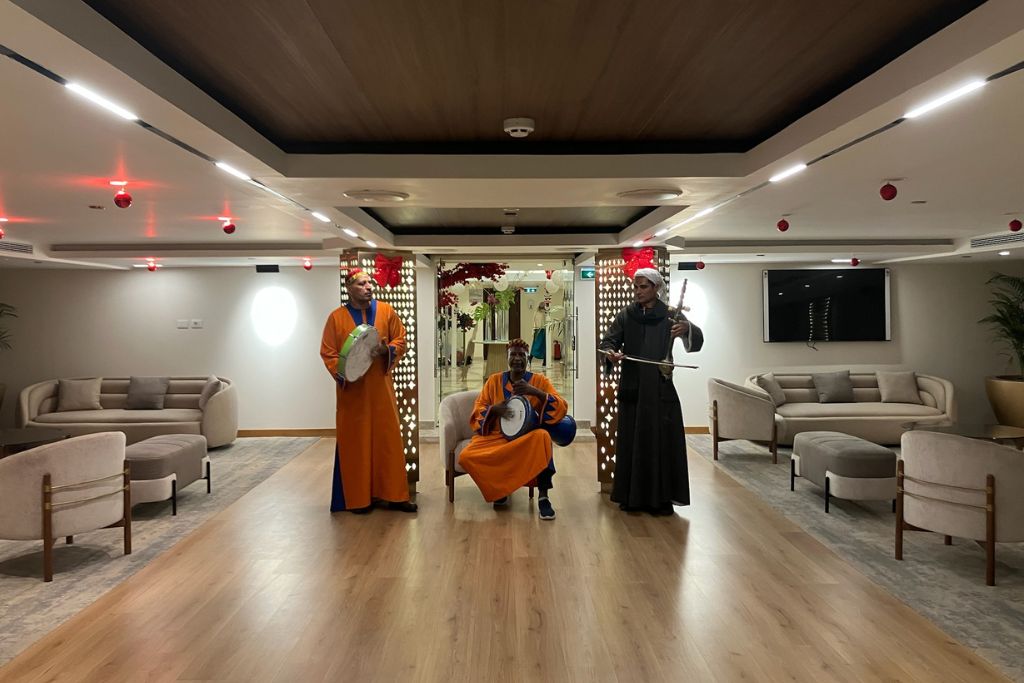 Three men in colorful traditional Egyptian dress performing music inside a Nile cruise lounge—ideal for blog content on all-inclusive Nile cruises, cruise ship entertainment, or cultural experiences between Luxor and Aswan.