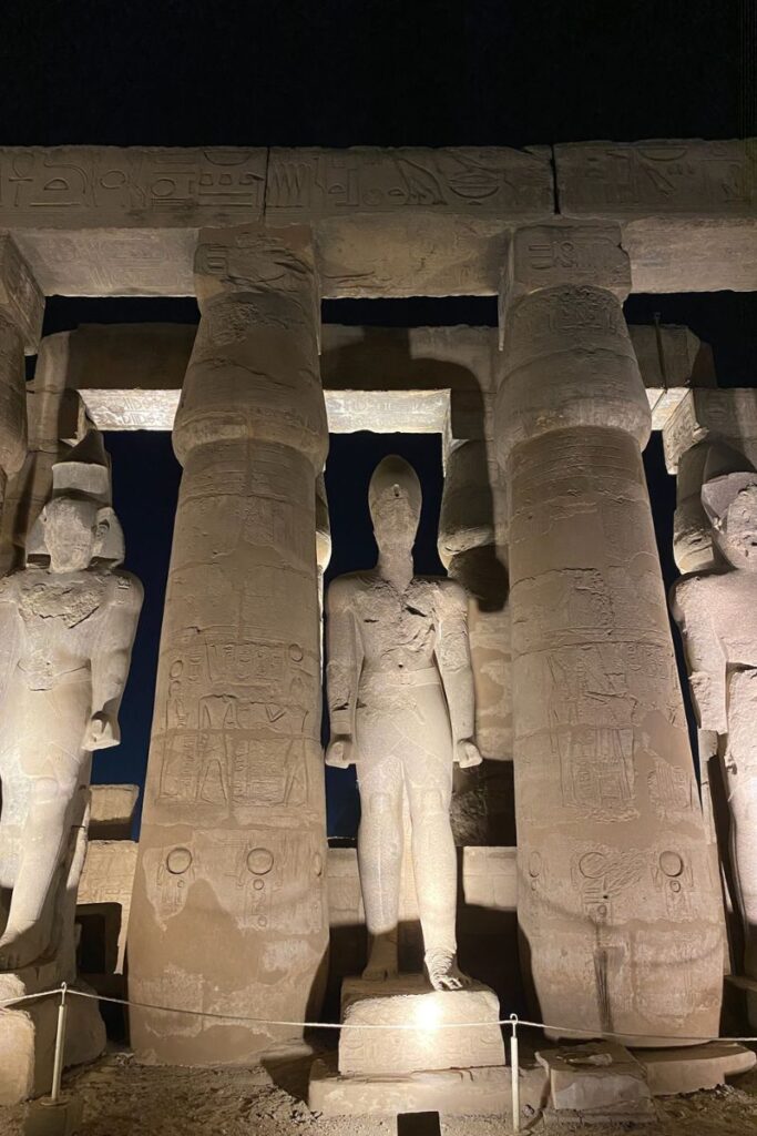 Large statues and stone columns illuminated at night at Luxor Temple—perfect for visitors exploring the temples of Luxor and enjoying Luxor temple at night.