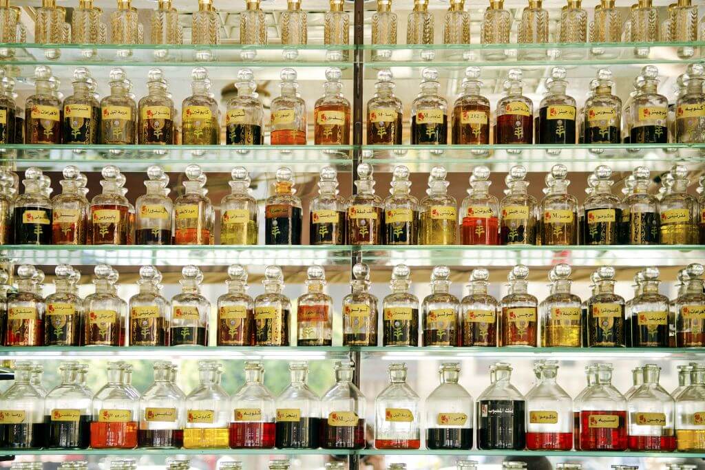 Shelves lined with rows of colorful Egyptian perfume bottles. A sensory shopping experience and one of the most unique things to do in Aswan.