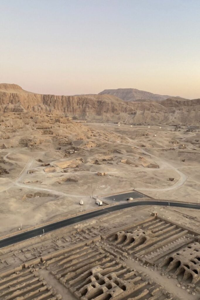 Aerial view of Luxor’s desert landscape dotted with tombs and ruins under soft sunset light. A historic highlight of day trips from Hurghada and a compelling destination for travellers wondering if Hurghada is worth visiting.