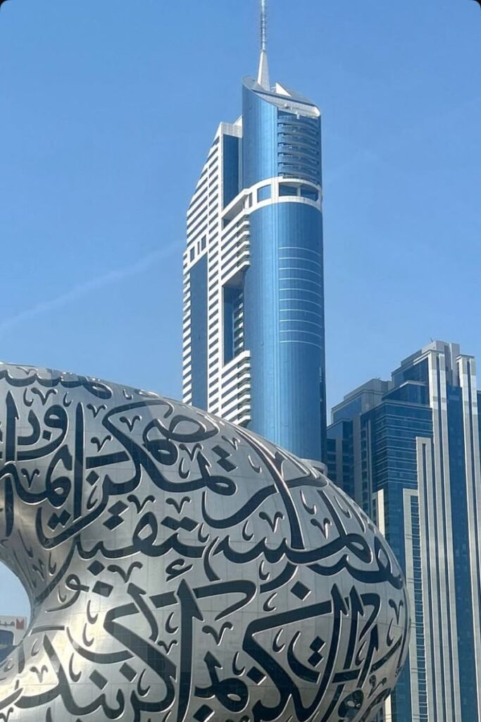 Modern skyscrapers in Dubai with the Museum of the Future in the foreground, featuring elegant Arabic calligraphy. A striking cityscape for blog posts about the best cities to travel solo in Europe or solo female travel Dubai.