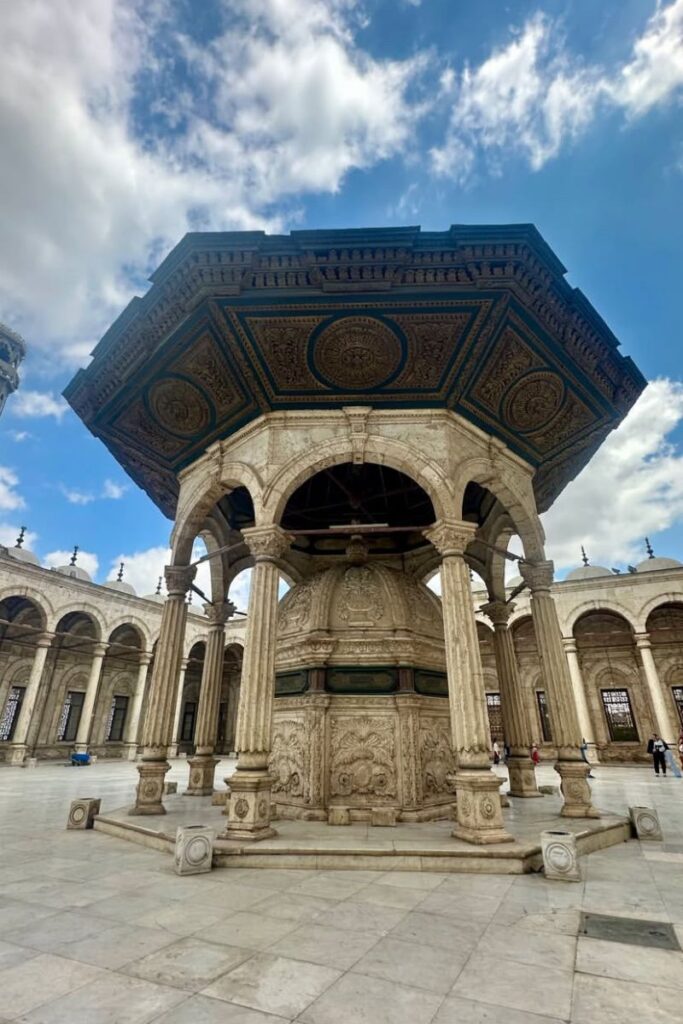 Ornate Ottoman-style ablution fountain with marble carvings and a detailed wooden canopy in the courtyard of the Mosque of Muhammad Ali in Cairo. A peaceful destination for solo female travelers exploring Cairo and wondering is Egypt safe for women.