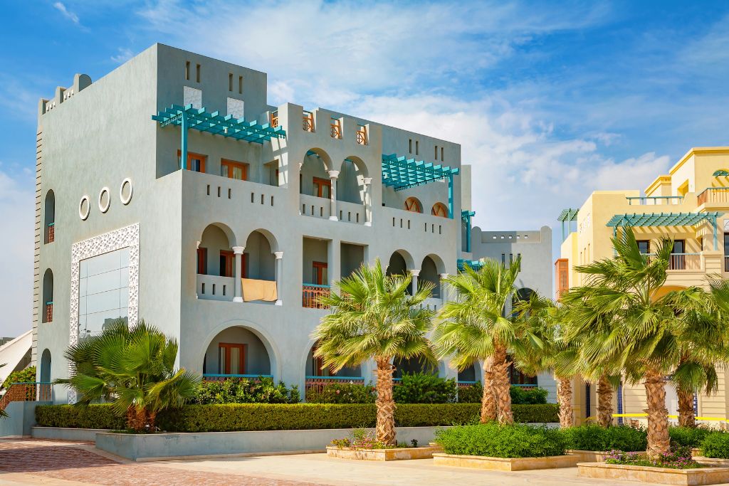 Contemporary hotel with geometric designs and palm-lined pathways in a coastal city, representing modern cities in Egypt and great places to visit in Egypt for resort stays.