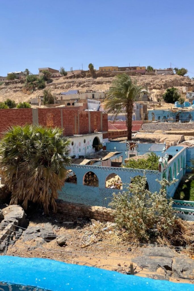 ChatGPT said: Colorful buildings with blue-painted walls and traditional Nubian architecture nestled in a hillside village near Aswan. A culturally rich and beautiful place to visit in Egypt for unique local experiences.