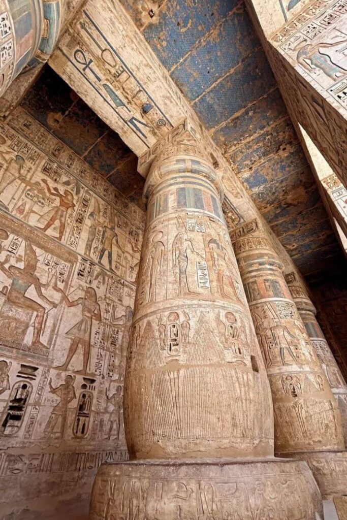 Close-up of colorful hieroglyphics and massive temple columns — part of your Egypt trip may include guided tours where tipping is expected. Get practical tipping advice and Egypt travel tips.