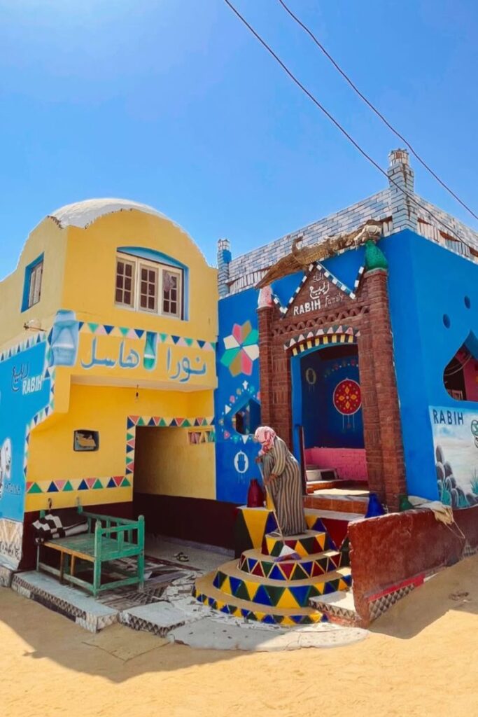 Colorful Nubian-style guesthouse with man outside — tipping in Egypt includes local hosts and small businesses. Learn practical Egypt tipping etiquette and cultural travel tips.