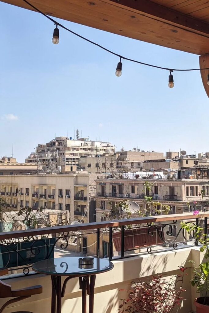 View of Cairo buildings from a hotel balcony — wondering about the cost to travel to Egypt and who to tip in the city? This image captures daily life and budget travel perspectives.