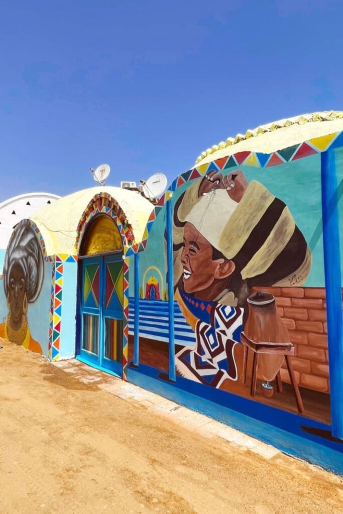 Brightly painted Nubian house with murals of joyful locals and geometric patterns in a village near Aswan. A culturally rich and welcoming destination when traveling to Egypt as a woman.