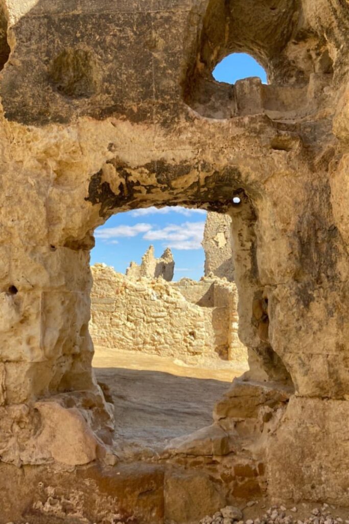 Crumbled stone archway with a view of weathered ruins under a bright sky, part of lesser-known Egyptian temple sites illustrating the diversity of the list of Egyptian temples.