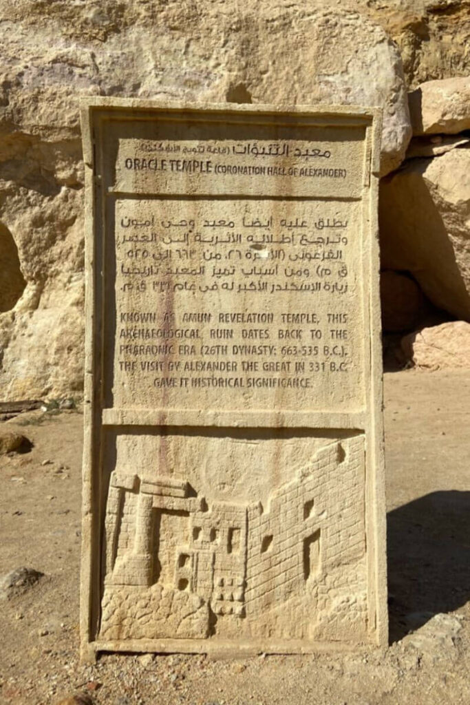 Informational sign at the Oracle Temple in Siwa Oasis, mentioning its historical relevance to Alexander the Great—part of the Egyptian temples list with strong historical significance.