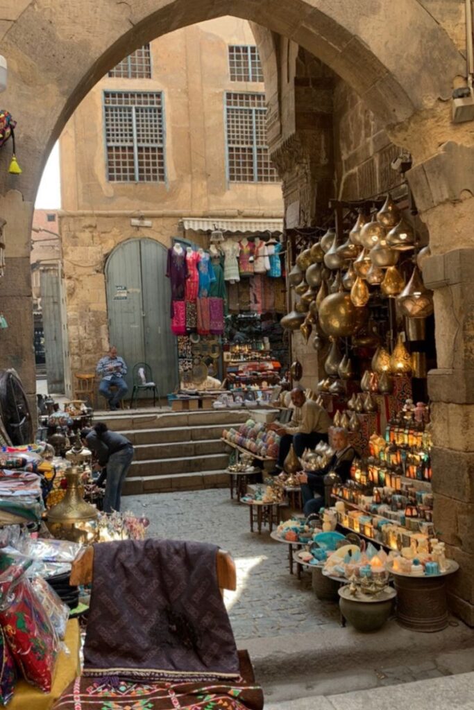 Vibrant market alley in Cairo’s Khan el-Khalili filled with brass lamps, textiles, and local vendors. A lively must-visit while traveling in Cairo and a reminder of Egypt safety tips for solo female travel in busy public spaces.