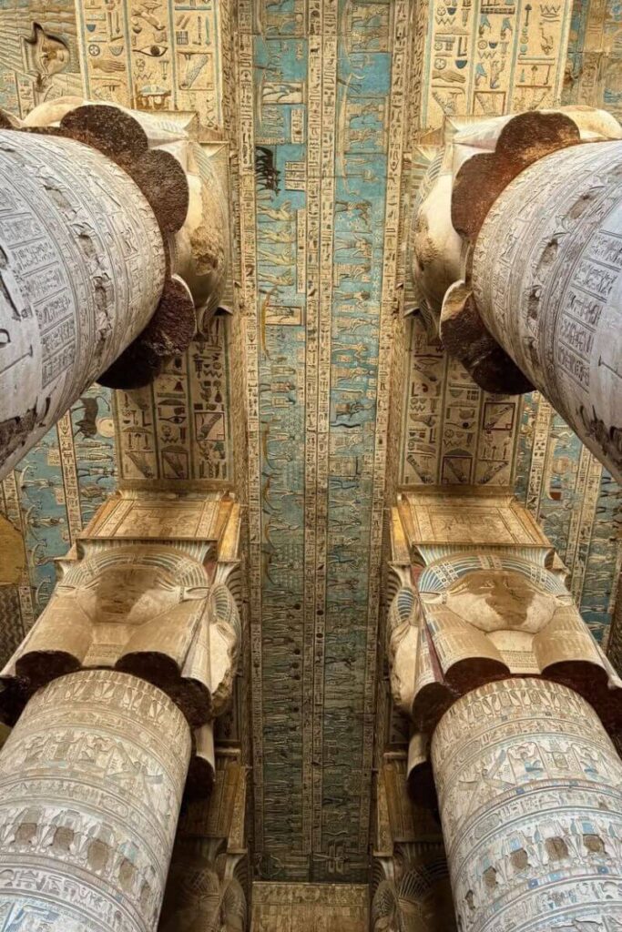 Vibrant blue and gold-painted ceiling of Dendera Temple with astronomical motifs and hieroglyphics, showcasing the sacred symbolism in Egyptian cult temples and the architecture of Egypt.