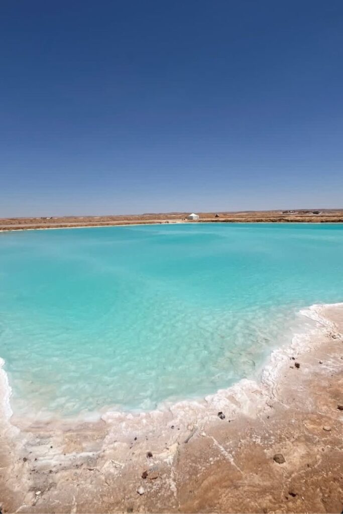 Crystal-clear turquoise lake surrounded by arid desert terrain, one of the most unique natural places to visit in Egypt. A stunning example of off-the-beaten-path experiences in Egypt.
