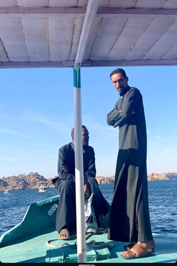 Two Egyptian boatmen in traditional dress on the Nile — tipping boat guides in Egypt is customary. Use this Egypt tipping guide to learn how much to tip and when.