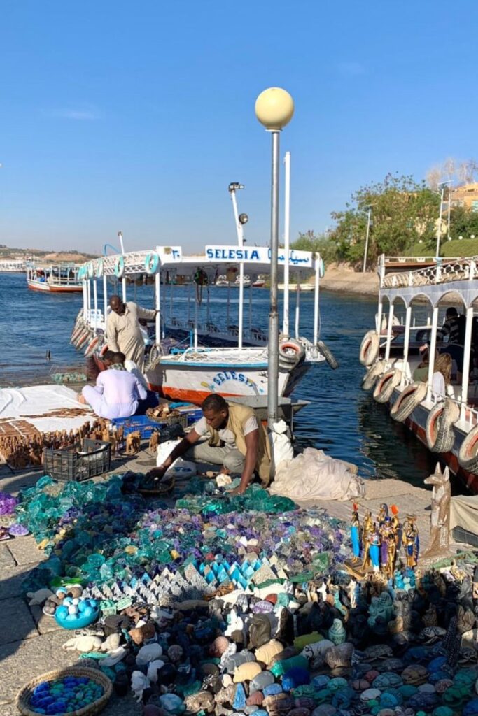 Vibrant street market near boats on the Nile in Aswan — wondering about tipping in Egypt’s markets? This guide offers Egypt travel tips and tipping etiquette for vendors and local sellers.