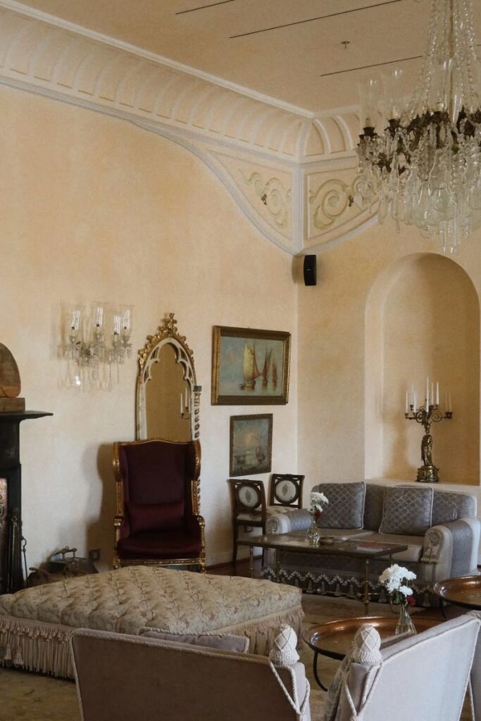 A luxurious sitting room with ornate chandeliers, velvet chairs, antique mirrors, and classical art, creating a regal ambiance. This elegant lounge is part of one of the best hotels in Hurghada Egypt for couples and embodies the timeless charm of luxury hotels in Hurghada Egypt.