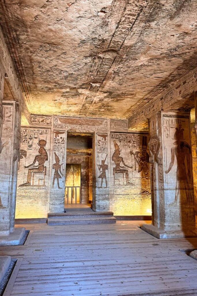 Intricately carved interior of Abu Simbel Temple, with detailed hieroglyphics and ancient Egyptian figures etched into sandstone walls. A prime example of ancient Egypt landmarks and one of the most famous landmarks in Egypt to visit for history lovers.