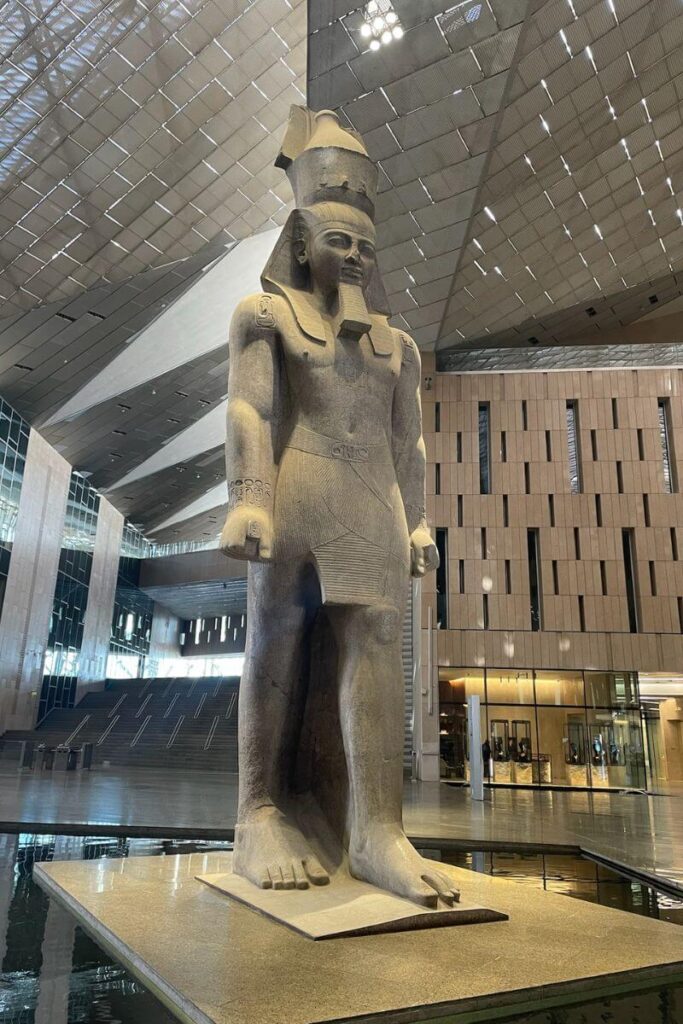 A towering statue of Pharaoh Ramses II stands inside the Grand Egyptian Museum's modern, light-filled atrium. Essential for any Egypt itinerary 10 days or Cairo Egypt itinerary.