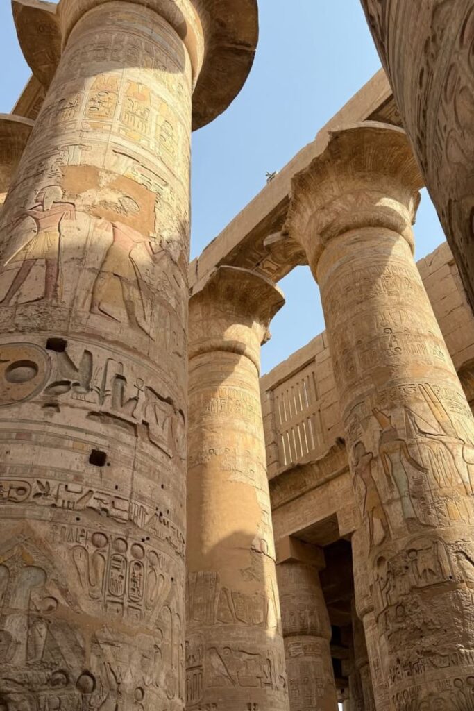 Towering, hieroglyph-covered columns in the Karnak Temple complex catch sunlight in Luxor. This archaeological wonder is essential to include in a 10 day Egypt itinerary or any detailed Egypt itinerary.