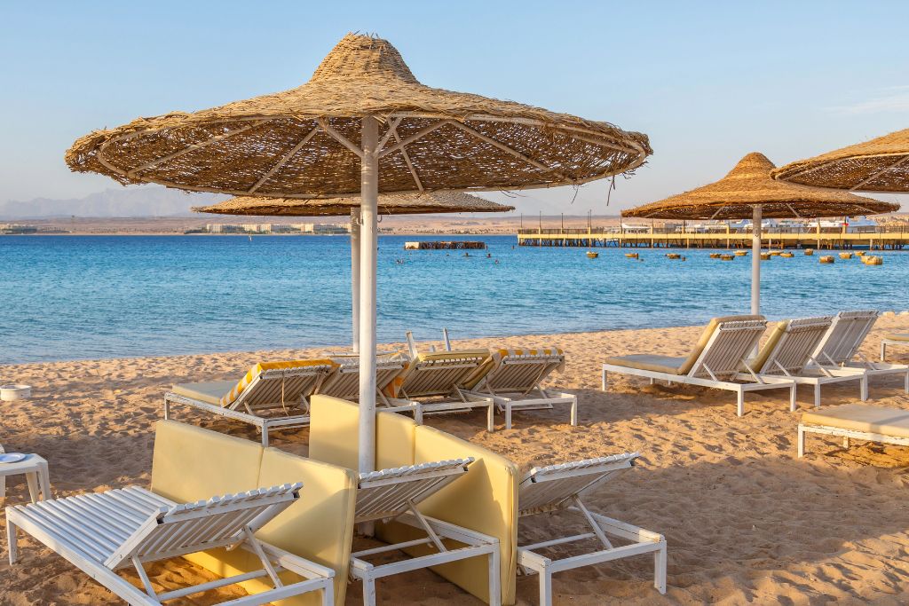 Serene beach scene in Sharm El Sheikh, Egypt – includes beach chairs and umbrellas overlooking the Red Sea. Great for travel advice for Egypt Sharm El Sheikh and tips for visiting Egypt during summer holidays.
