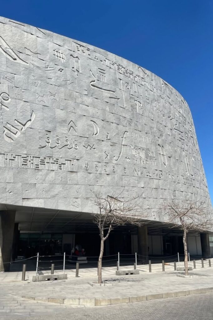 Exterior of the Bibliotheca Alexandrina, with its curved wall engraved with scripts from various alphabets. This modern landmark is a cultural addition to an Egypt itinerary 10 days or a coastal itinerary in Egypt.