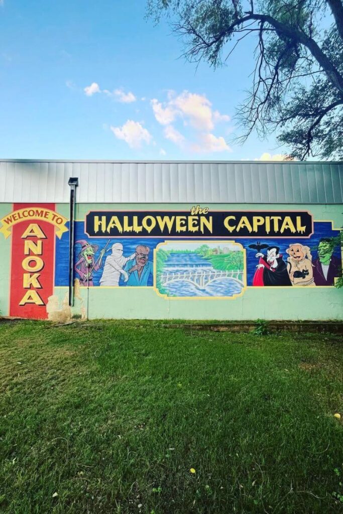 A colorful mural in Anoka, Minnesota, reading “Welcome to the Halloween Capital” with classic monster illustrations, celebrating one of the best Halloween towns to visit.