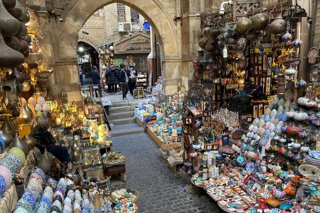 A colorful market alley in Khan el-Khalili bazaar in Cairo filled with lamps, ceramics, spices, and souvenirs. A must-see stop on any Cairo Egypt itinerary or when planning an Egypt travel itinerary.