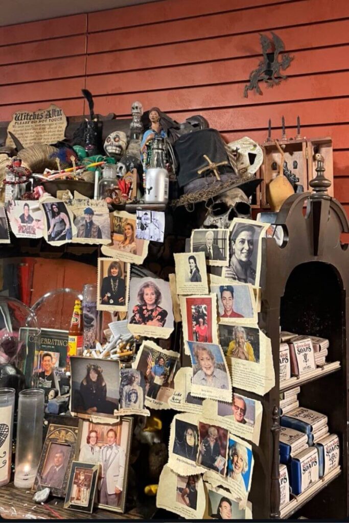 A cluttered altar filled with skulls, dolls, potions, candles, and celebrity photos inside a witchcraft shop, an intriguing stop for those seeking Halloween fun activities and cool places to go for Halloween in the US.