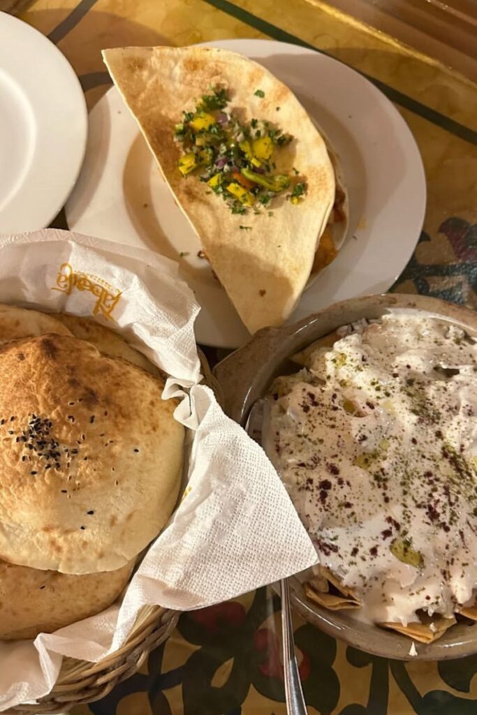 Delicious spread of Egyptian food featuring flatbread, creamy dips, and fresh wraps garnished with herbs. Food tours are one of the most fun activities to do in Egypt and top unique experiences in Egypt.