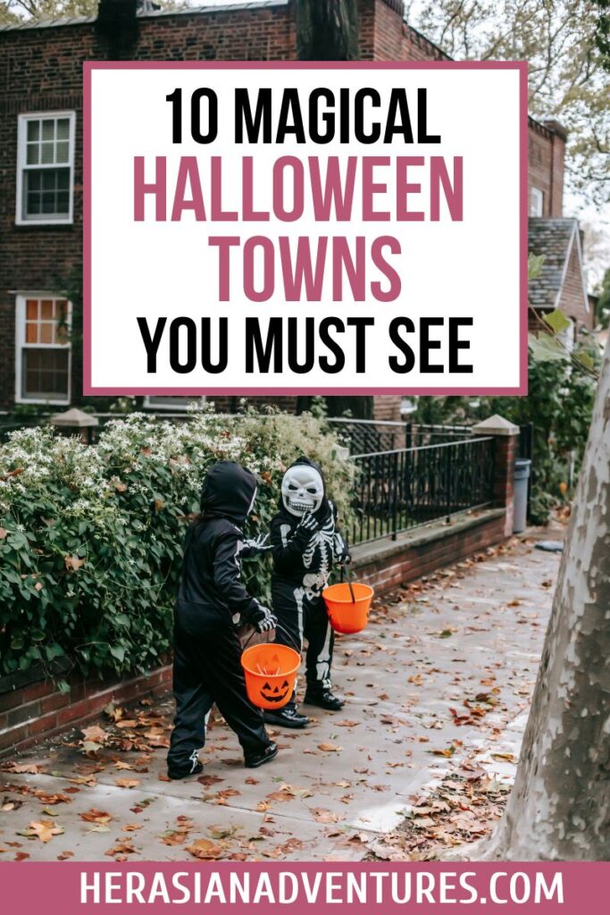 Two children in skeleton Halloween costumes carry orange pumpkin candy buckets along a sidewalk with autumn leaves, overlaid with the text “15 Magical Halloween Towns You Must See” and website “herasianadventures.com,” highlighting magical Halloween towns to visit with kids.