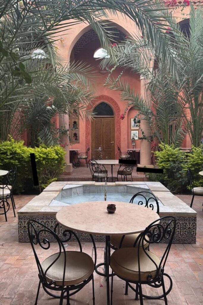 Charming Egyptian hotel courtyard with lush palms, tiled fountain, and arched doorways – perfect for travelers seeking travel advice for Egypt, where to stay in Cairo, and tips for visiting Egypt in comfort and style.