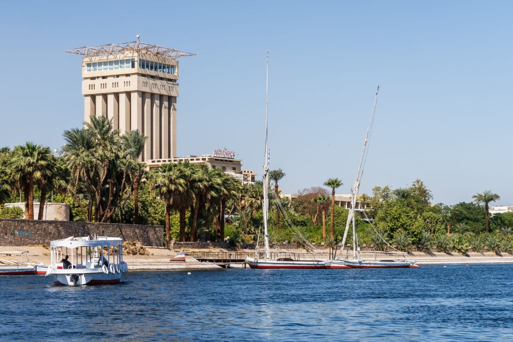 View of felucca boats sailing on the Nile with the Mövenpick hotel in the background – perfect for showcasing serene Nile moments and including travel tips for Egypt, where to stay, and what to do in Luxor or Aswan.