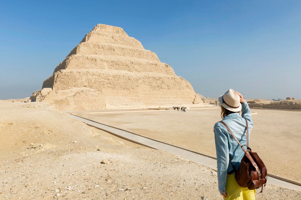Female traveler exploring the ancient Step Pyramid in Saqqara, Egypt – ideal for first-time travel tips Egypt, advice for visiting pyramids in Egypt, and what to know before going to Egypt’s archaeological sites.