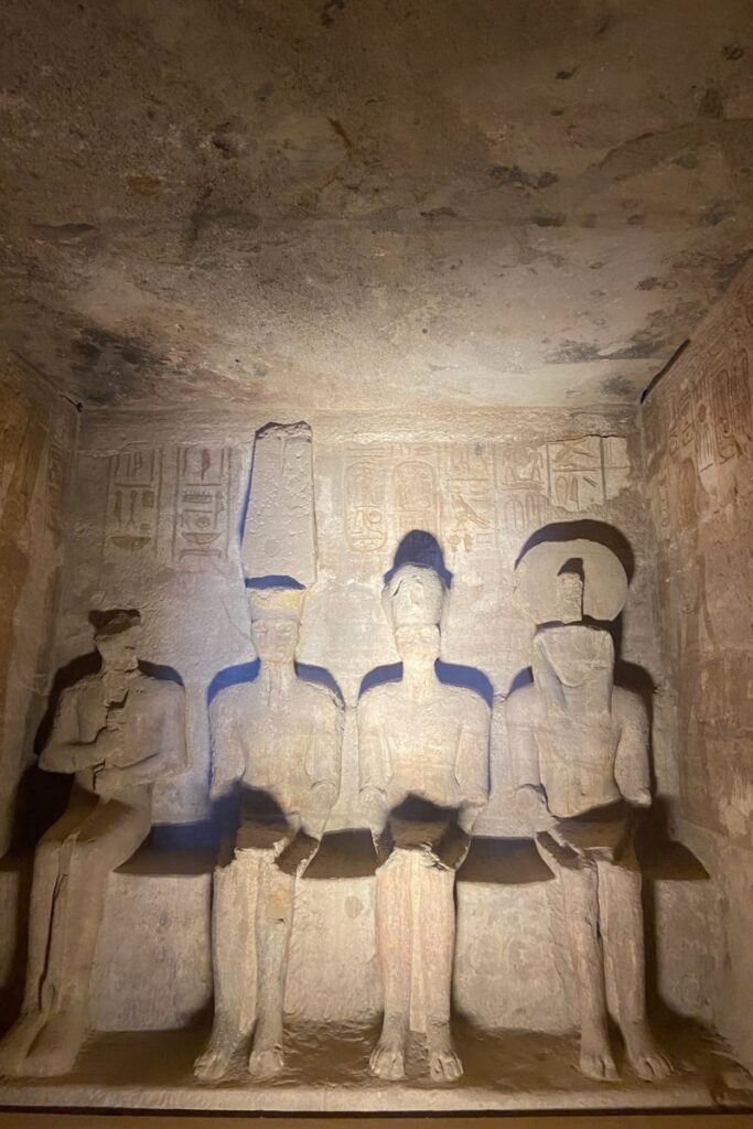 Stone statues of seated deities and pharaohs inside a dark, ancient chamber at Abu Simbel. This mystical space offers one of the most spiritual and unique experiences in Egypt for archaeology fans.