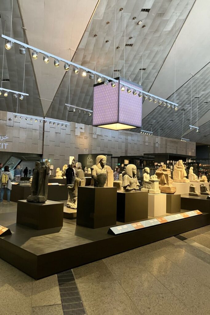 Stone sculptures of pharaohs and gods inside the sleek, modern Grand Egyptian Museum. A visit here is a top thing to do in Egypt and one of the best non-touristy things to do in Egypt for history buffs.