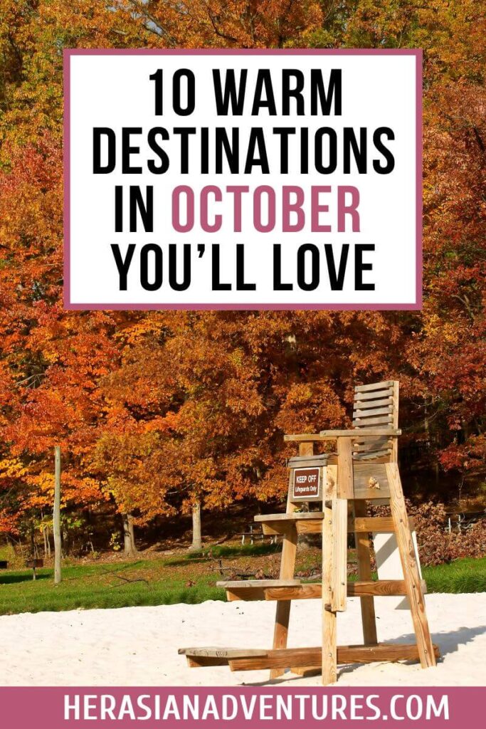 An autumn-themed travel graphic with colorful fall leaves, a sandy beach, and a wooden lifeguard stand reads “10 Warm Destinations in October You’ll Love.” Ideal for travelers looking for where is warm in October in the USA or planning a vacation during the fall season.