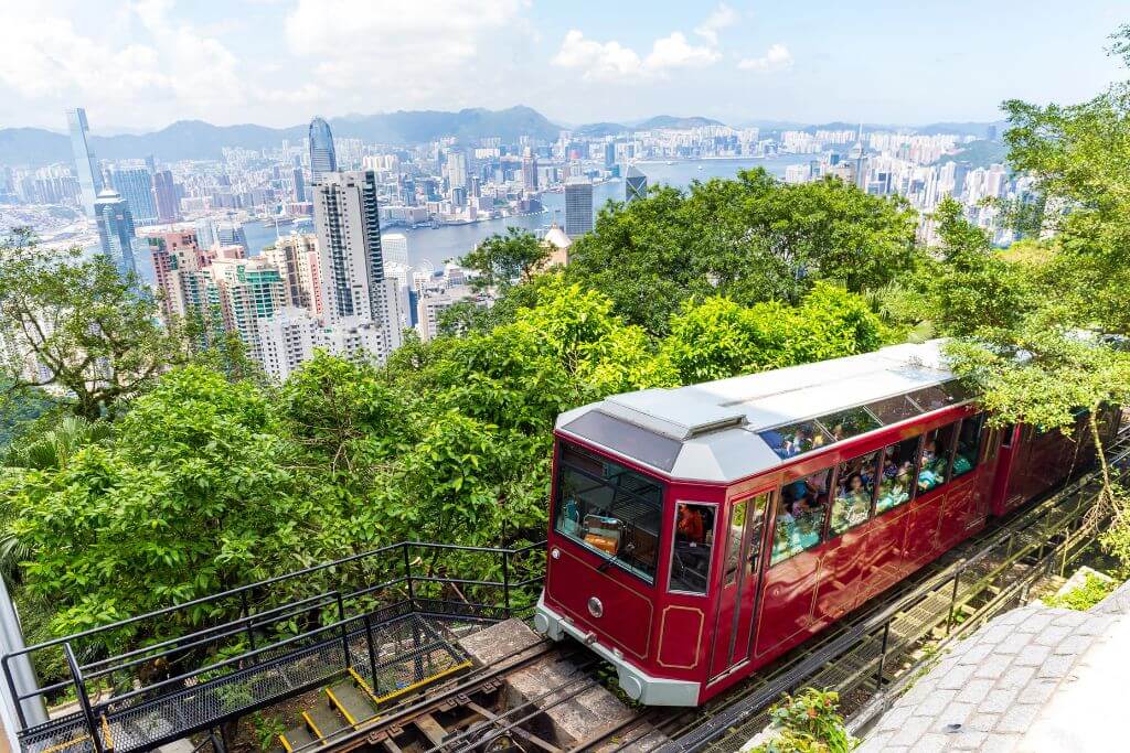 A red Peak Tram ascends through dense greenery with sweeping views of Victoria Harbour and Hong Kong’s skyscrapers. This iconic ride is one of the best things to do in Hong Kong and belongs on every Hong Kong itinerary.