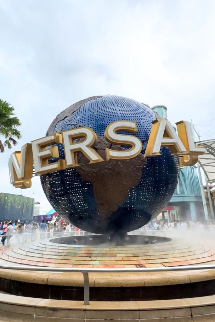 The iconic spinning globe fountain at Universal Studios Singapore with crowds of visitors around it. A family favorite stop for anyone comparing Singapore vs Hong Kong theme parks.