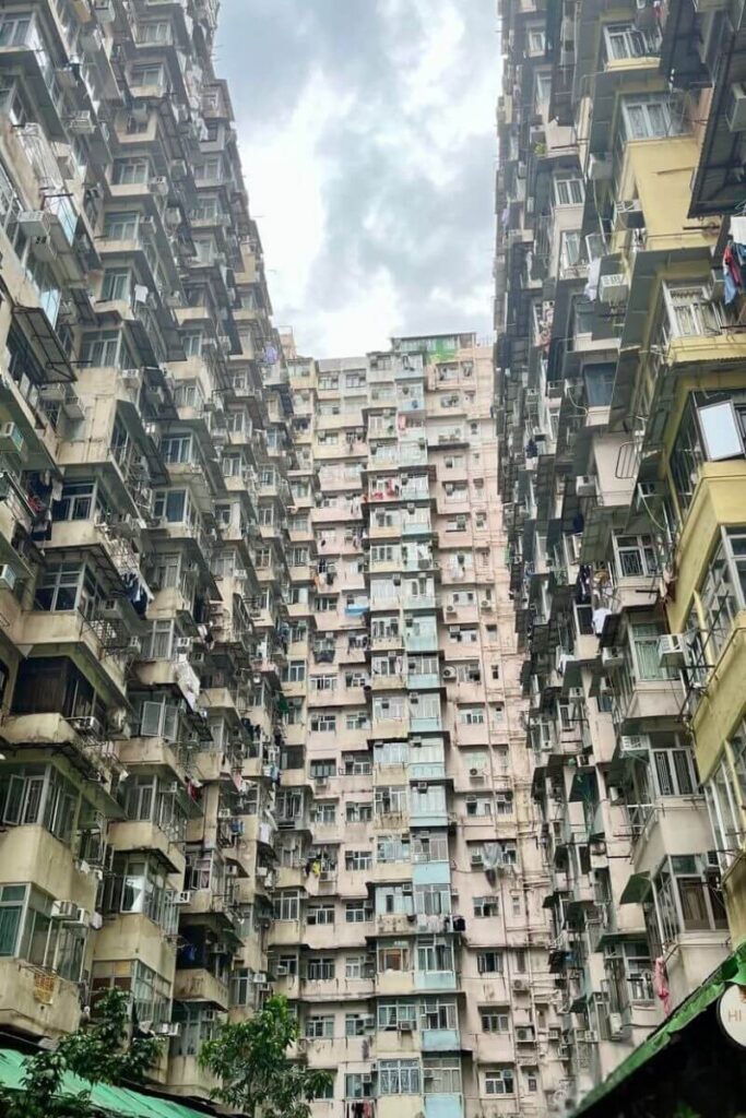 A dramatic upward view of the dense and layered Monster Building in Quarry Bay, with stacked apartments and open windows filling the frame. This Instagram-famous spot is one of the most unusual places to visit in Hong Kong and a popular stop for cool things to do in Hong Kong.