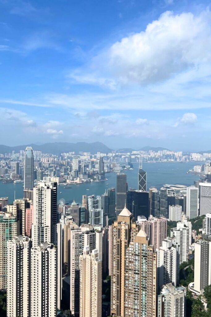 Panoramic view of Hong Kong’s skyscrapers and Victoria Harbour from Victoria Peak on a clear day. A must-know Hong Kong tourist tip is to visit The Peak for the city’s most breathtaking skyline views.