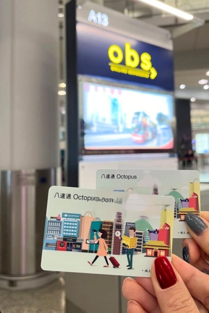 Close-up of two Octopus Cards held at a station kiosk, used for transport and shopping in Hong Kong. Getting an Octopus Card is one of the most important tips for visiting Hong Kong and avoiding travel mistakes.
