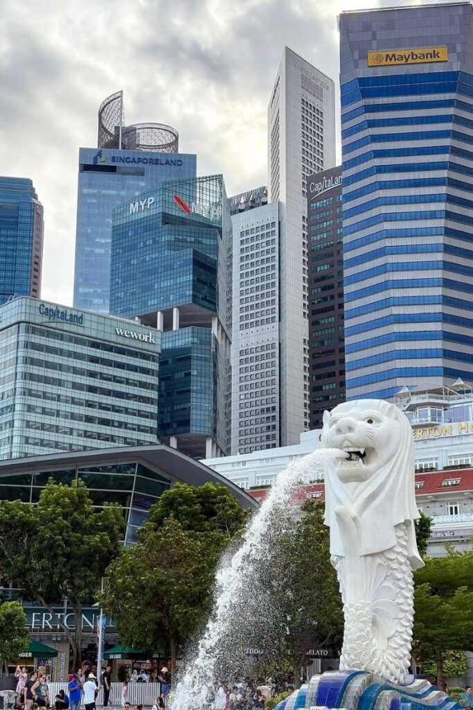The iconic Merlion statue spouts water with Singapore’s modern financial district as a backdrop. A top photo spot for travelers comparing Singapore vs Hong Kong attractions.