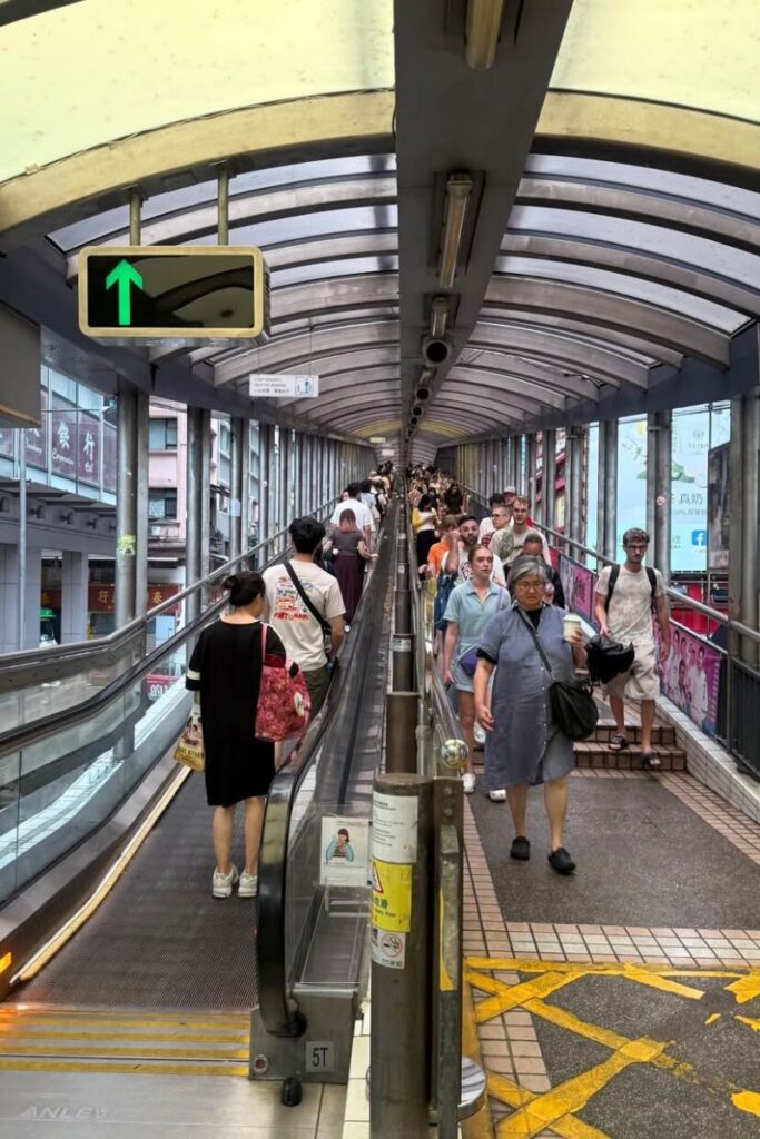 Crowds ride the covered Central–Mid-Levels Escalator in Hong Kong, the world’s longest outdoor covered escalator system. A key Hong Kong travel tip is to use it for exploring Central easily.