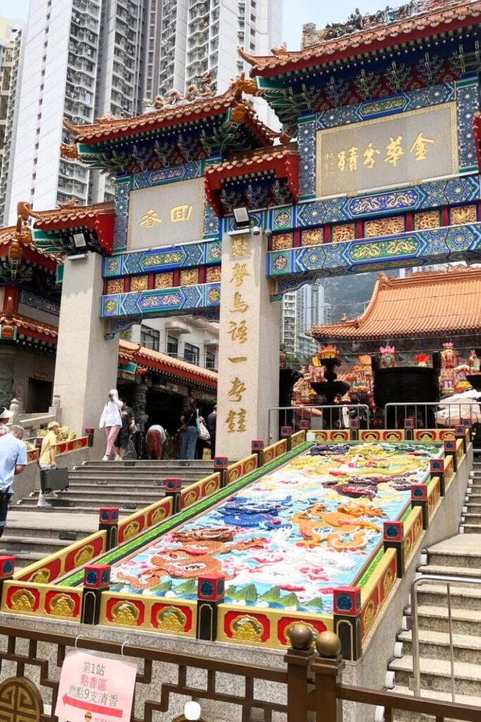 The colorful entrance of Wong Tai Sin Temple with intricate carvings, golden calligraphy, and dragon mosaics. Visiting temples is among the top tips for Hong Kong travel and an essential stop for cultural insight.
