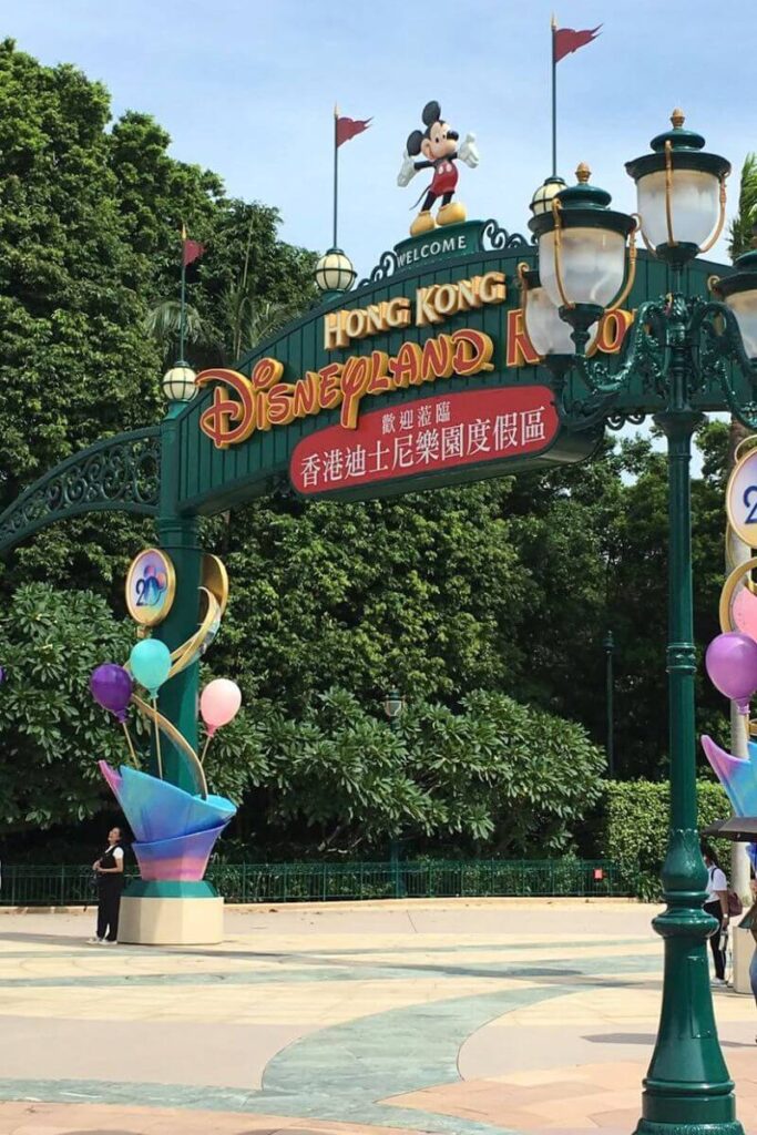 Entrance gate to Hong Kong Disneyland Resort with Mickey Mouse statue on top, colorful balloons, and welcome signage. A must-visit stop for any Hong Kong travel guide and perfect for first-time visitors looking for essential Hong Kong tips.