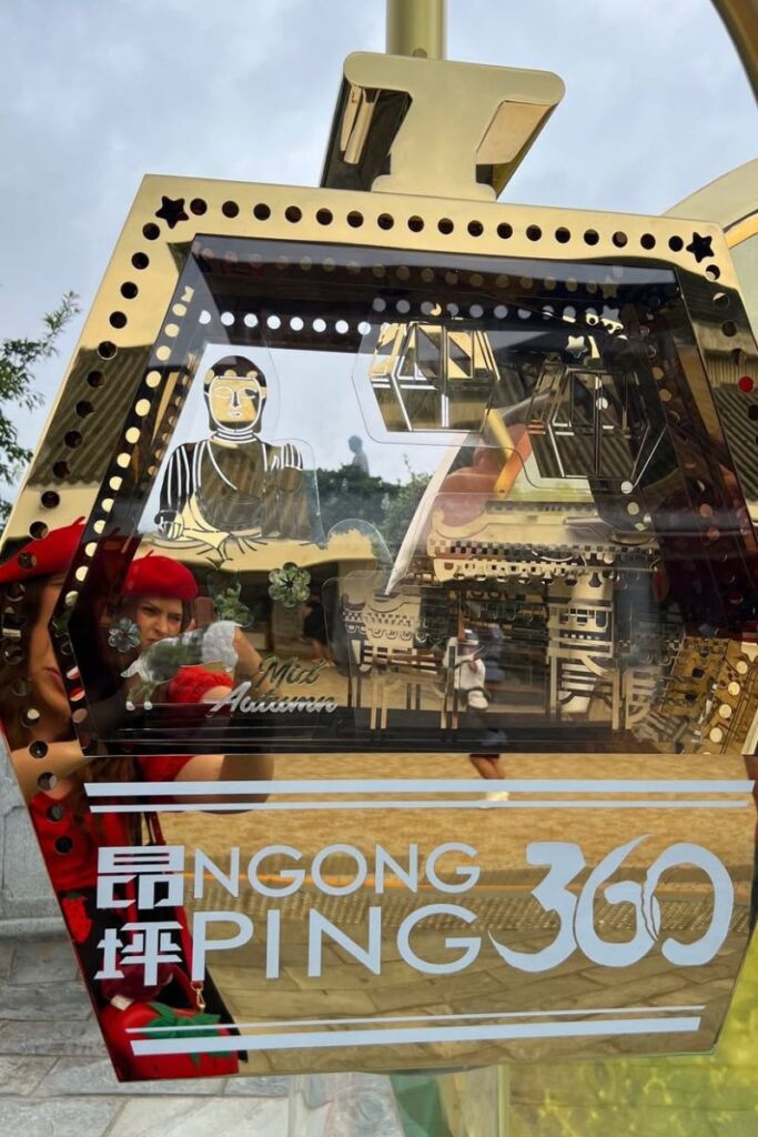 Decorative Ngong Ping 360 display with a golden Buddha and cable car illustrations, celebrating the Mid-Autumn Festival near the Big Buddha Hong Kong.