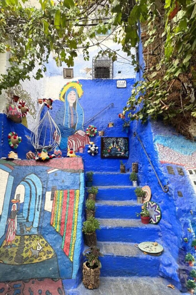 Colorful blue walls covered in local art and handmade crafts line a staircase, an inviting spot for those exploring warm places to visit in December and vibrant winter travel destinations.
