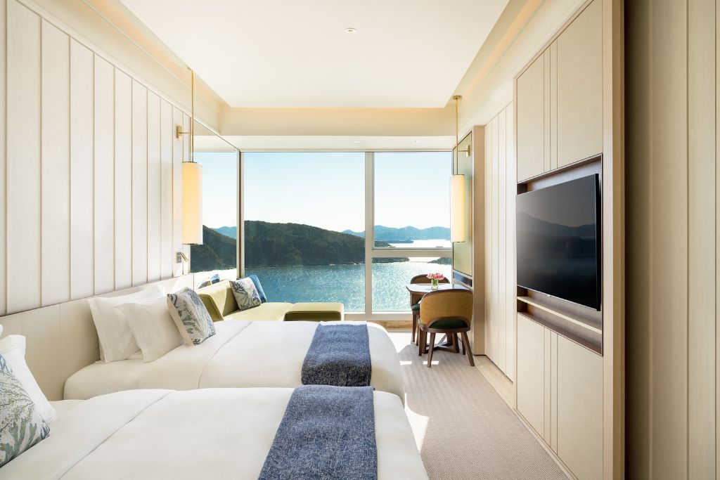 Modern hotel room with twin beds and floor-to-ceiling windows overlooking the South China Sea. A relaxing stay option near the Big Buddha in Hong Kong and Lantau Island attractions.