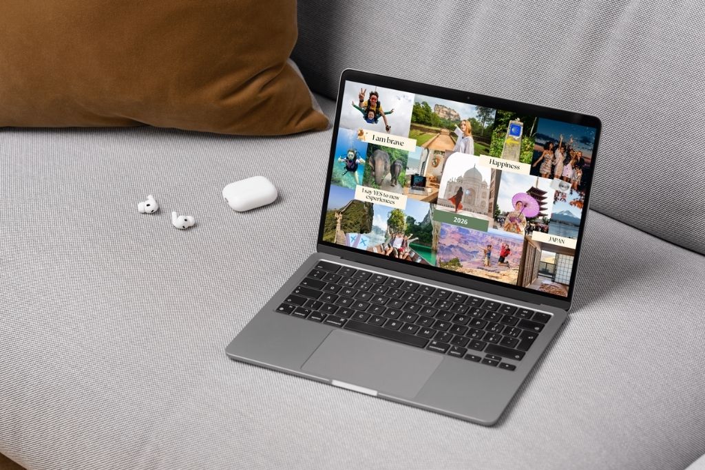 A laptop displays a colorful travel vision board collage with global destinations, great for creating an online travel vision board or aesthetic travel dream board wallpaper.